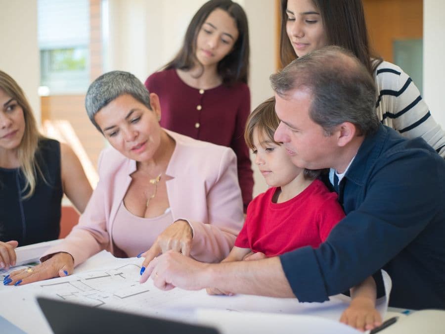 A family sitting around a table together, going through paperwork and planning.