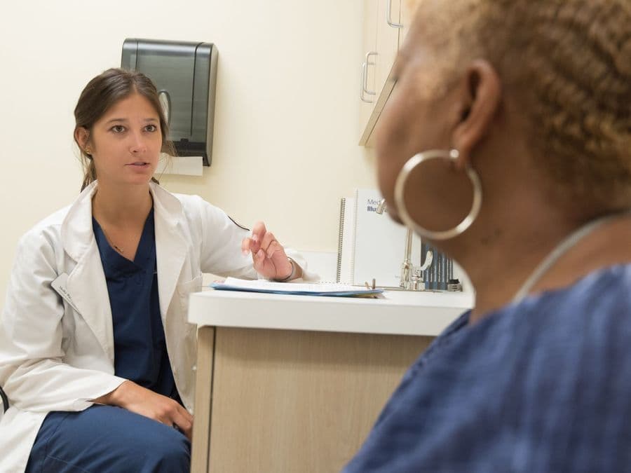 A clinician talking through a care plan with a patient across a desk.
