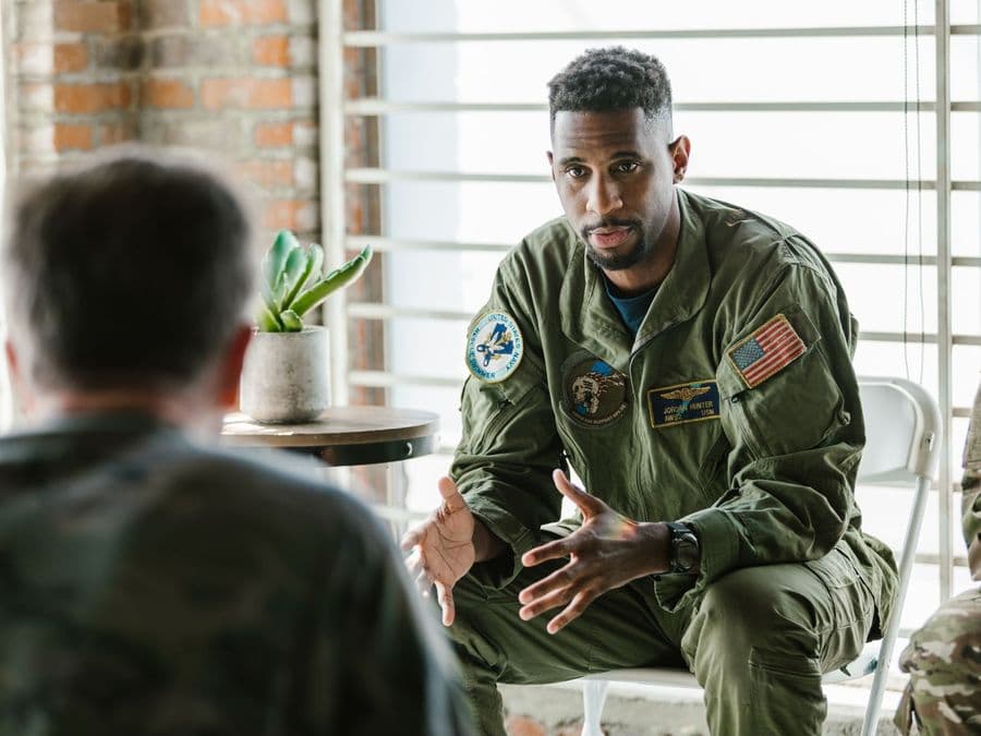 Two military veterans sitting together in conversation.