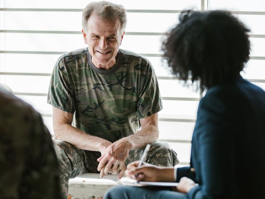 A veteran talking with a counsellor who is sitting opposite him.